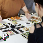2 personnes qui jouent au Jeu Ludoshi – petits chevaux version sushi