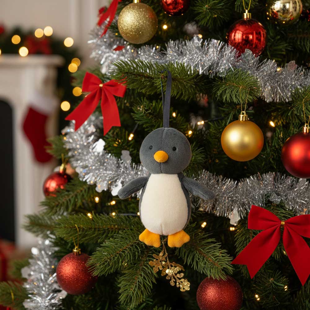 Peluche à suspendre Pingouin Festive Folly de Jellycat dans un sapin de Noël
