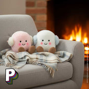 Peluche Duo guimauve hiver Rose et Blanc Marshmallows Toastie Amuseables de Jellycat dans un canapé avec plaid