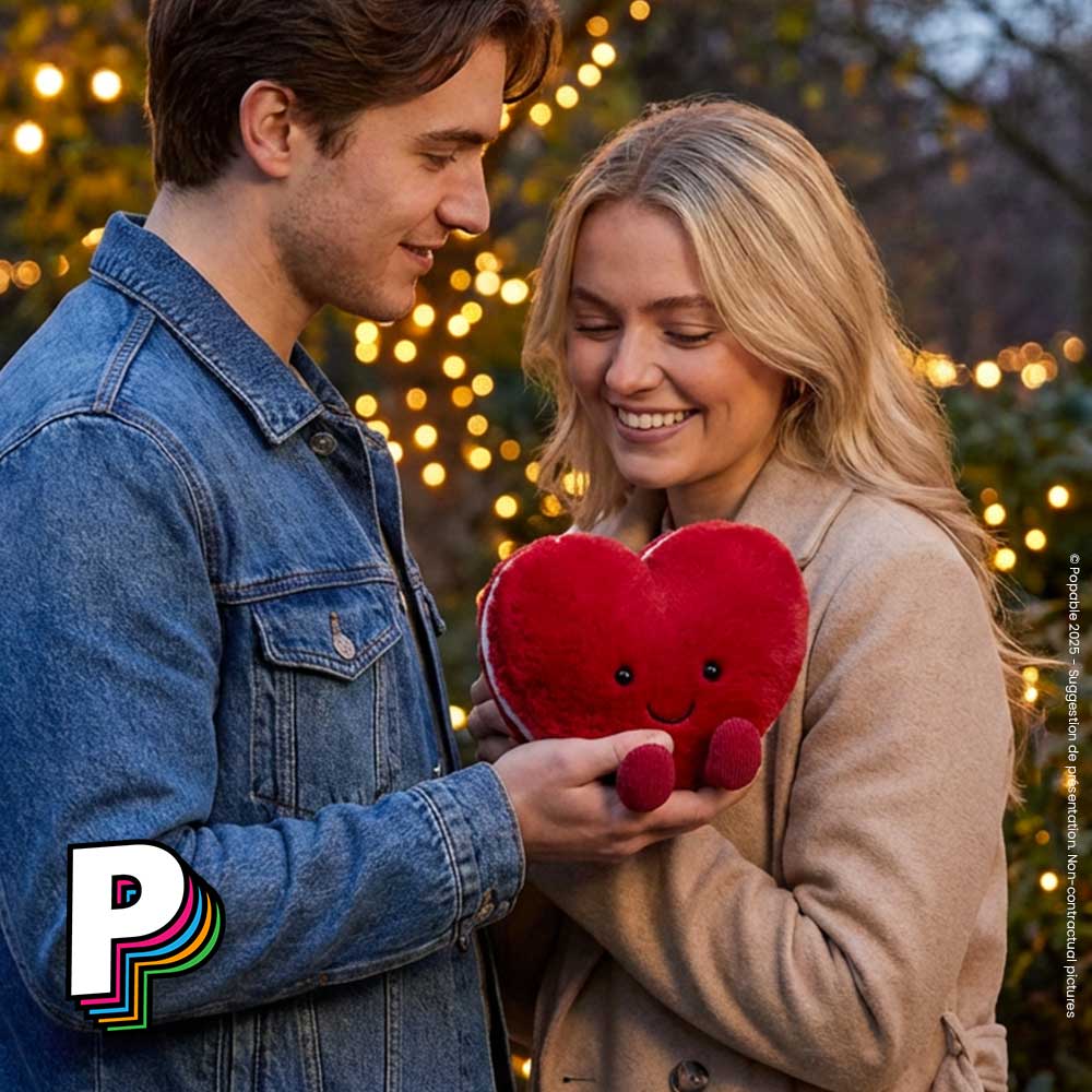 Jeune homme qui offre Peluche coeur rouge Macaron Arlette Amuseables de Jellycat à jeune femme dans un parc