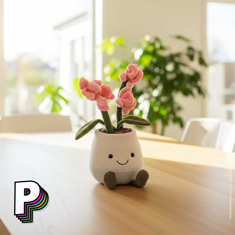 Peluche orchidée rose en pot Amuseables de Jellycat sur une table à manger