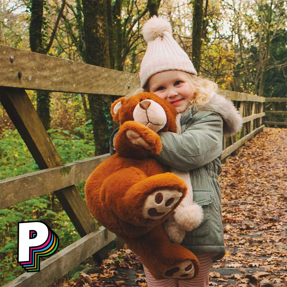 Petite fille qui fait calins à ours en peluche