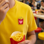 Pin’s Frites 🍟 Des frites! Des Frites! Des Frites! sur tee-shirt avec un jeune homme qui mange des frites