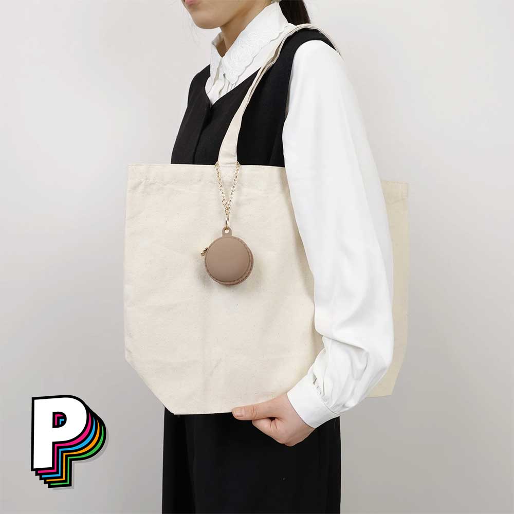 Trousse & Porte-clé Macaron Chocolat de YUP! accroché à un sac