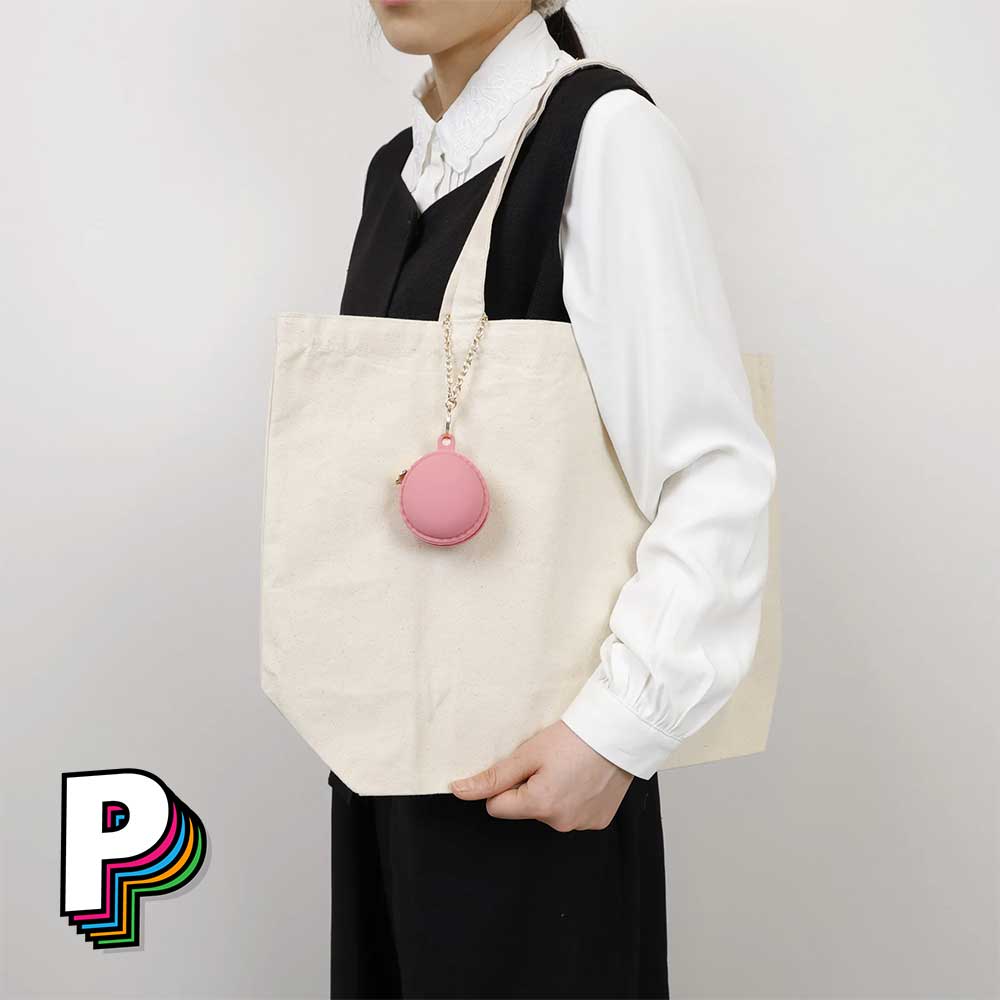 Porte-clé trousse Macaron Framboise de YUP! accroché à un sac