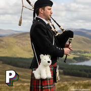 Sac bandoulière Munro scottie bag  de Jellycat porter par un homme qui joue de la cornemuse en Ecosse 